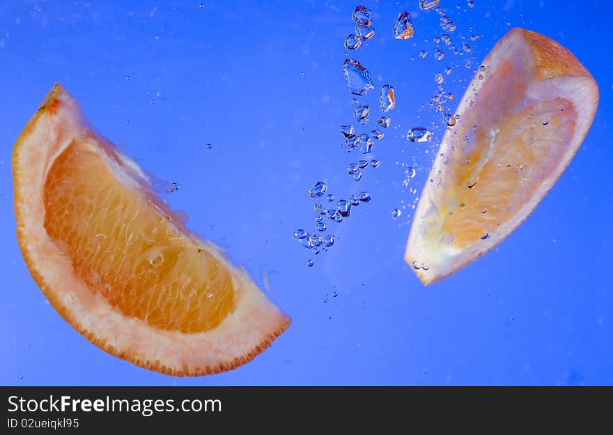 Fresh orange in the blue water. Fresh orange in the blue water