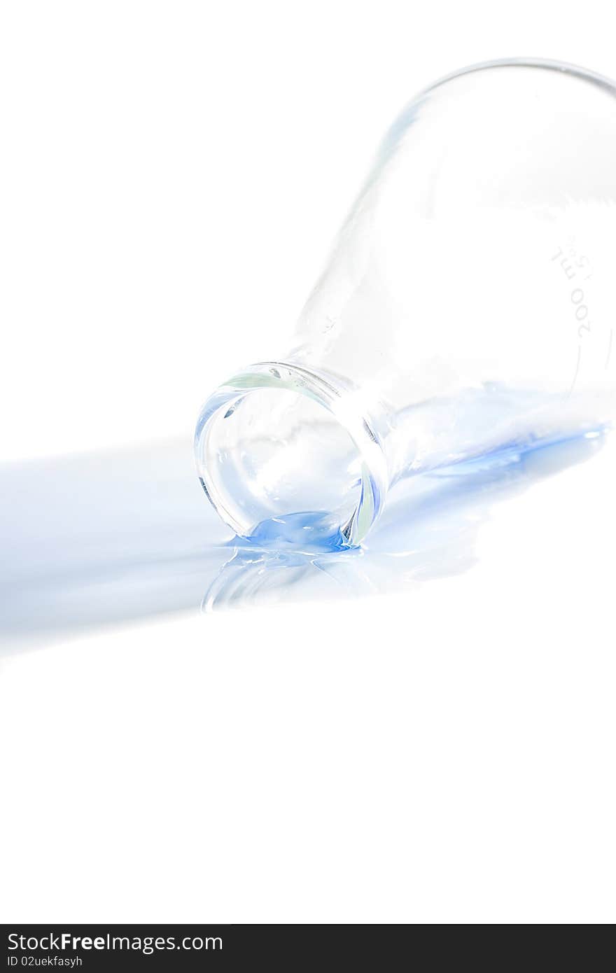 A blue liquid spilled from an erlenmeyer flask on a white background. A blue liquid spilled from an erlenmeyer flask on a white background.