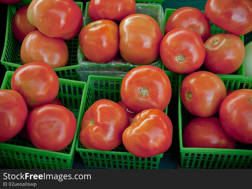 Tomatoes in green baskets in afarmer s market