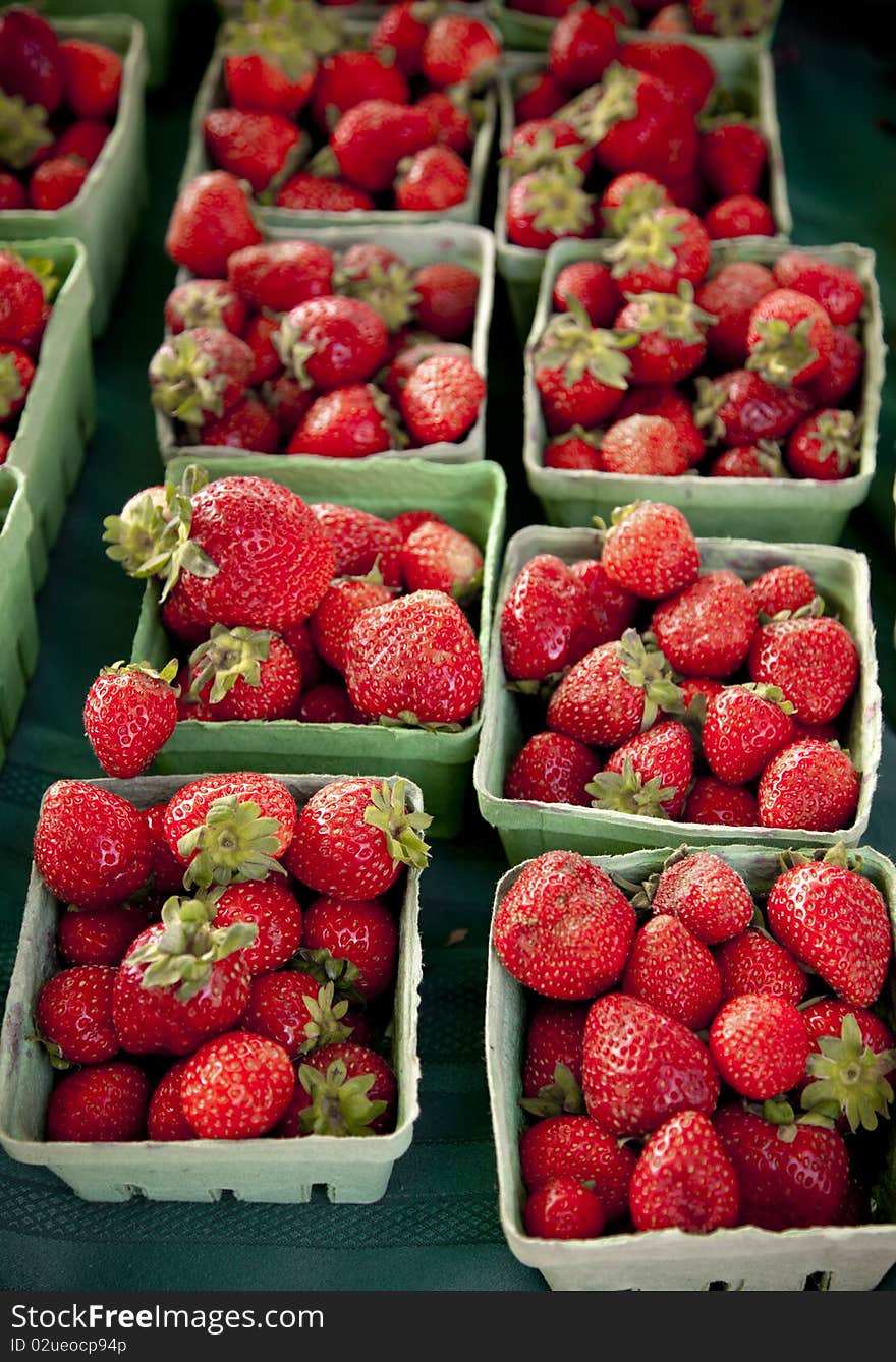 Strawberries in green boxes, vertical