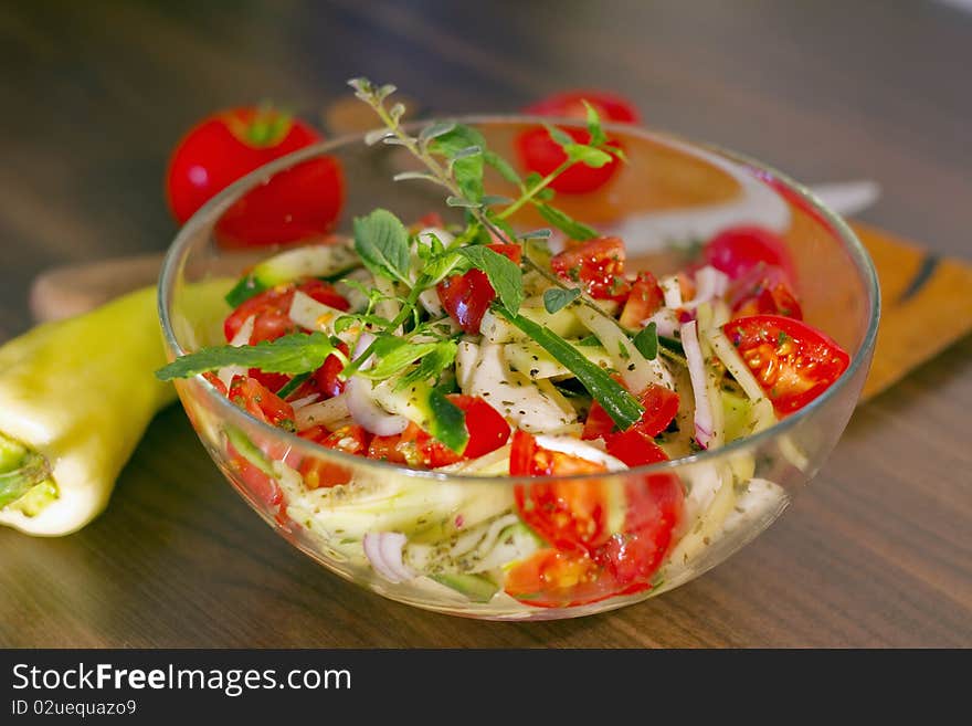 Salad of tomato, pepper, cucumber and purple onion, in olive oil, with menta and oregano sprig. Salad of tomato, pepper, cucumber and purple onion, in olive oil, with menta and oregano sprig.