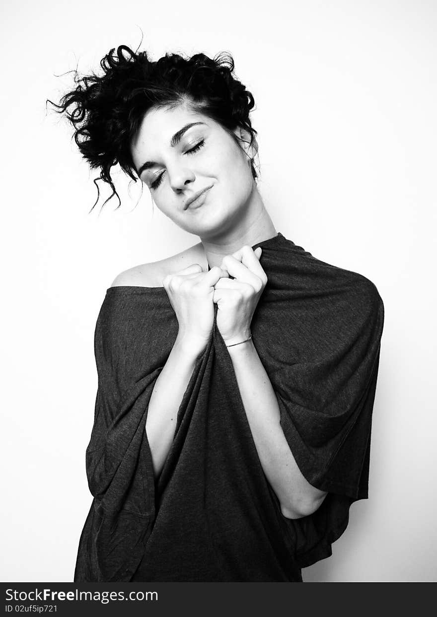 Young woman with curly black hair hugging herself. Young woman with curly black hair hugging herself