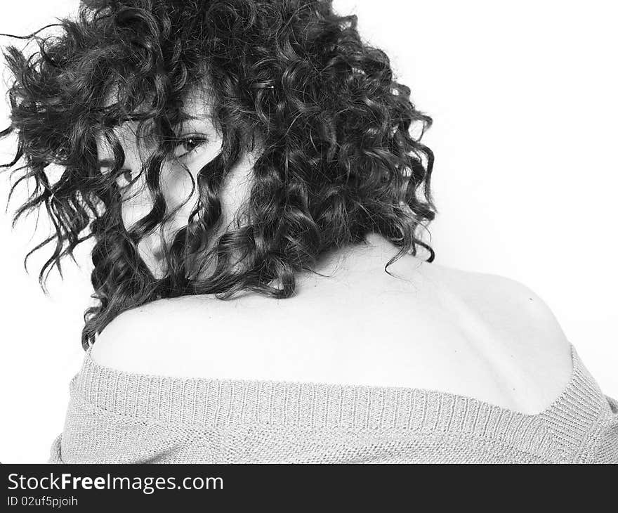 Young woman with curly hair looking back