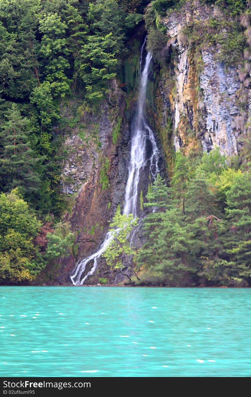 A waterfall cascading down a mountainside into a lake near Interlachen. A waterfall cascading down a mountainside into a lake near Interlachen