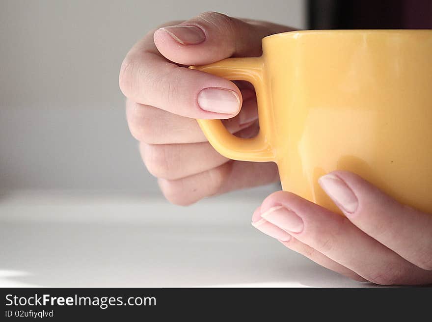 The woman is holding the cup in her arms. The woman is holding the cup in her arms.