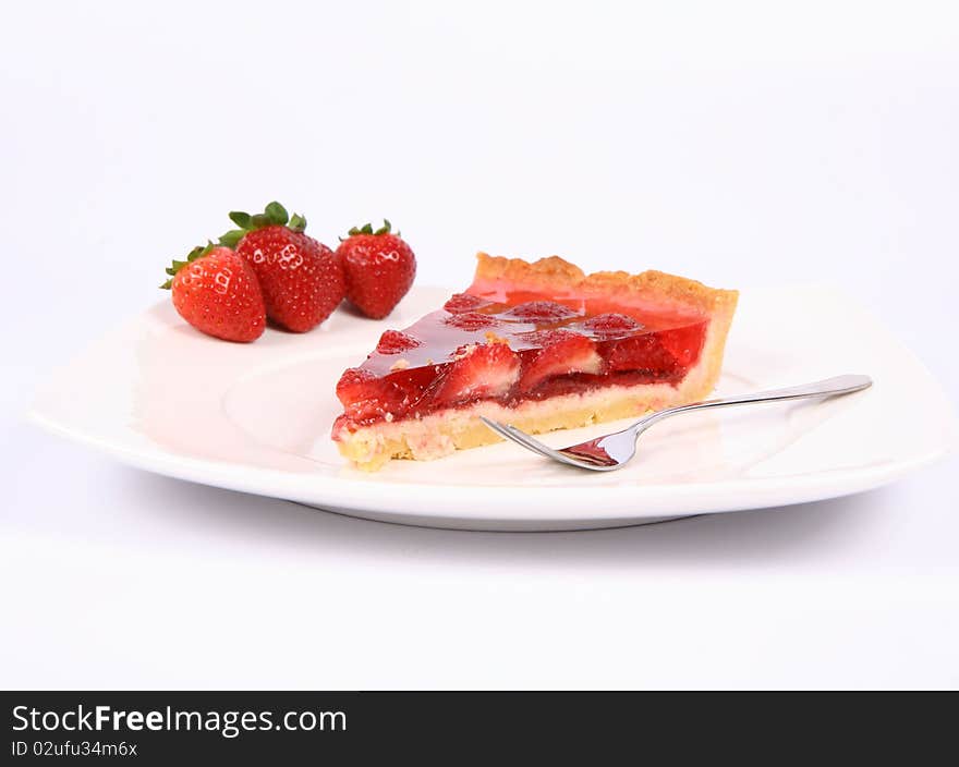 Piece of Strawberry Tart on a plate decorated with strawberries, and a fork