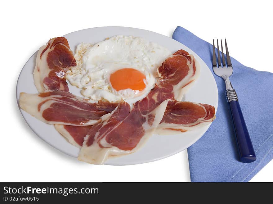 Plate with a fried egg and slices of ham on white background isolated. Plate with a fried egg and slices of ham on white background isolated