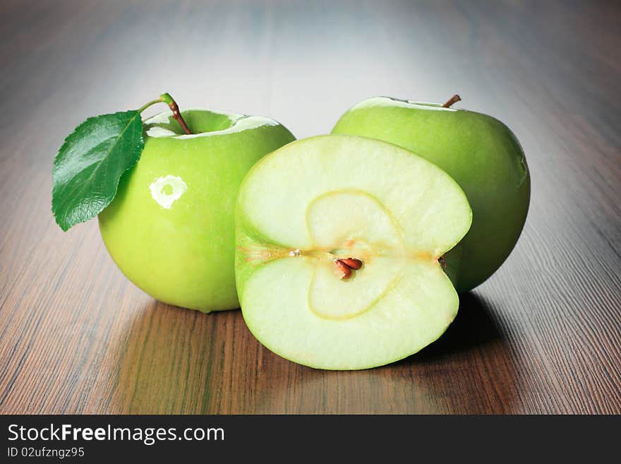 Shot of fresh green apples with green leaf on a table.