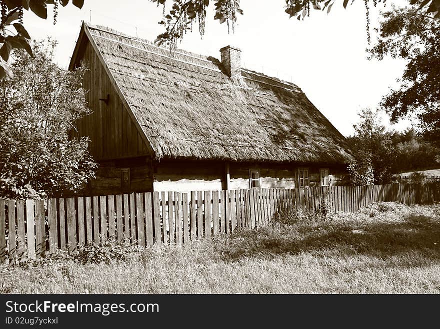 Old thatched cottage surrounded with an old fence