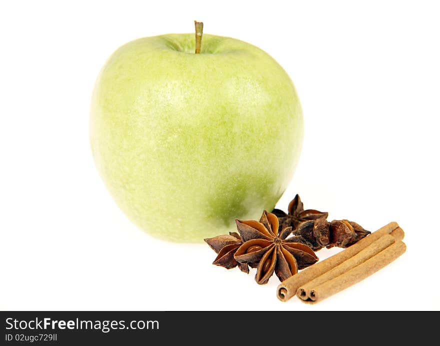 Delicious fresh green apple with anise stars and cinnamon sticks isolated on white.