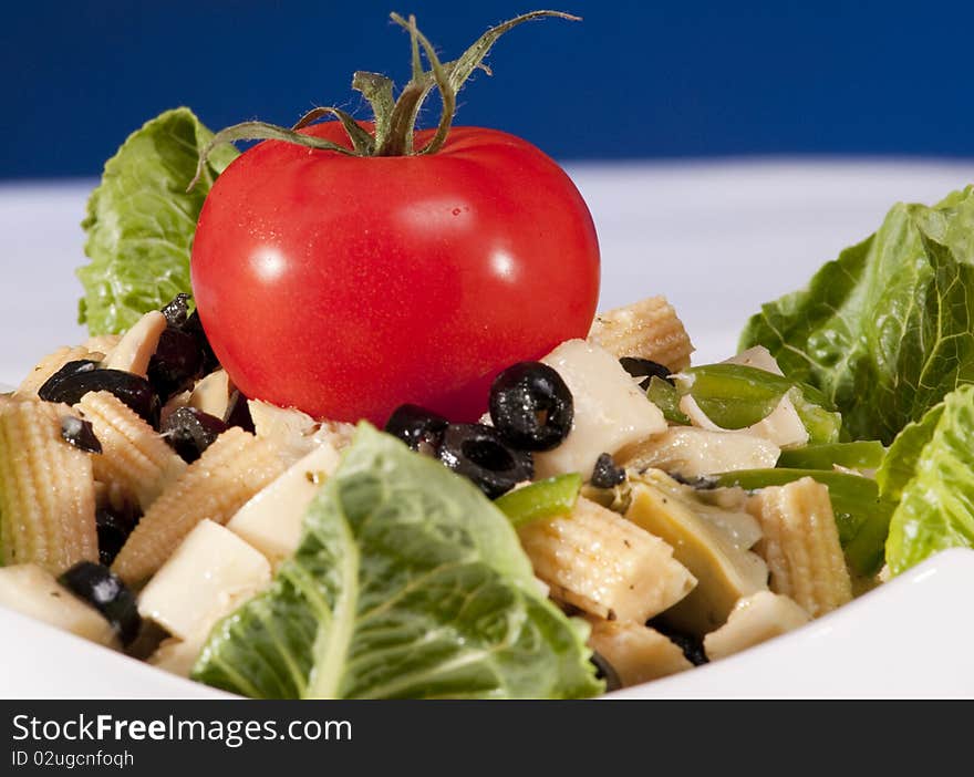 Antipasto salad with lettuce, tomatoes, olives and corn