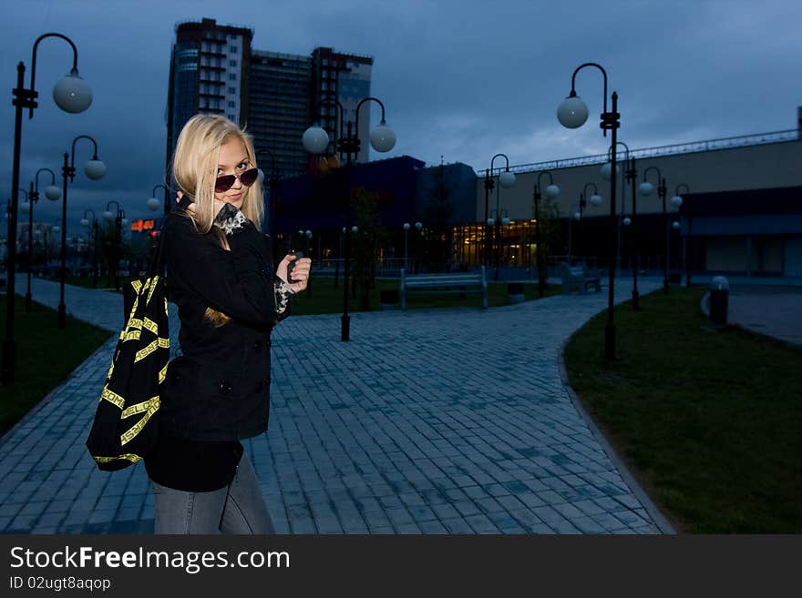 Young beauty posing over night city, evening background. Young beauty posing over night city, evening background