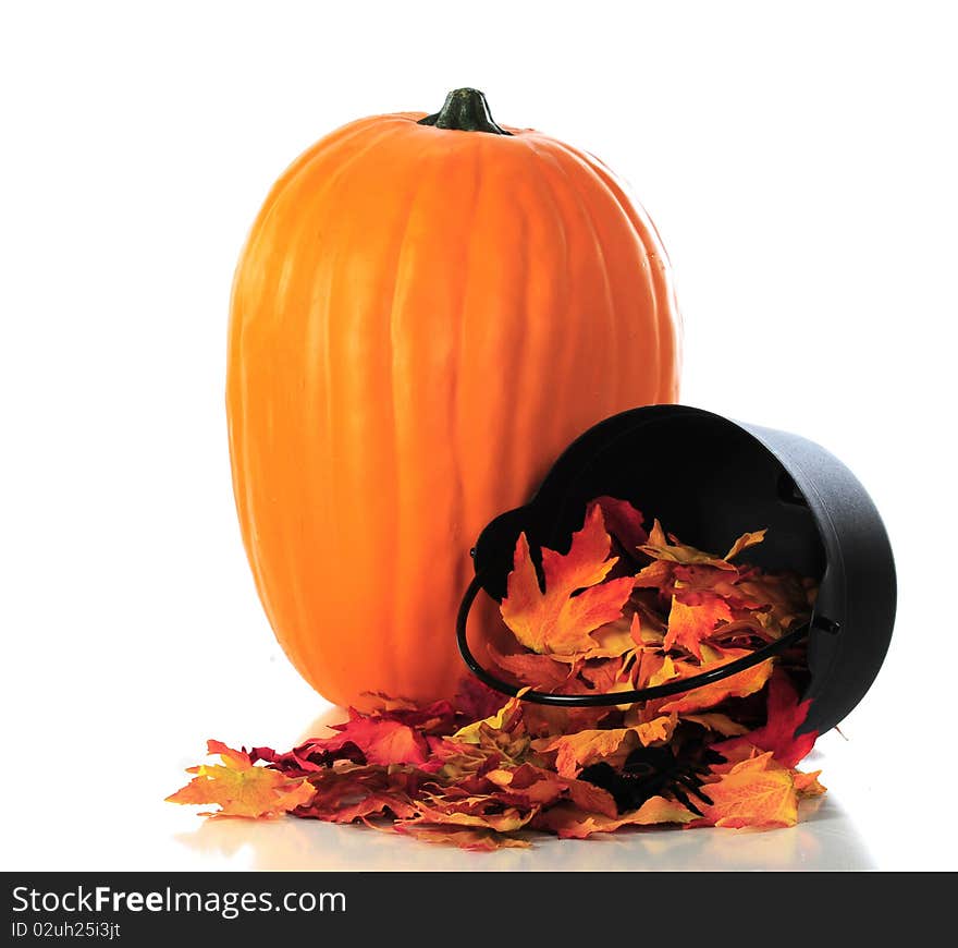 A simple still-life composed of a large pumpkin and colorful leaves spilling out of a small, tipped cauldron. Isolated on white. A simple still-life composed of a large pumpkin and colorful leaves spilling out of a small, tipped cauldron. Isolated on white.