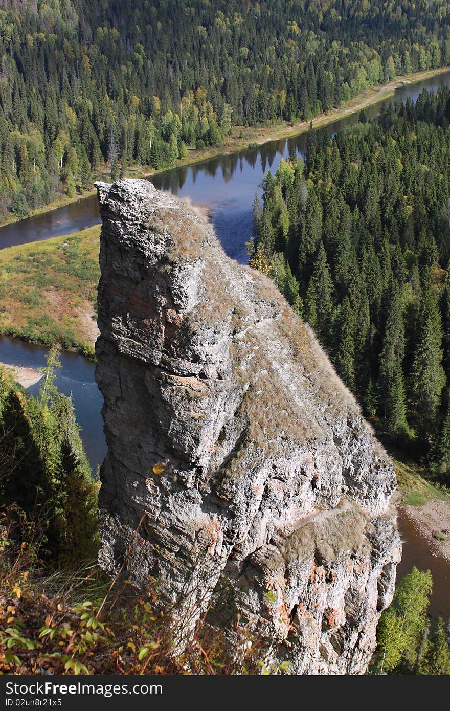 Natural rock against the river and wood