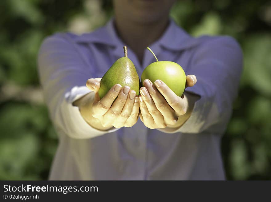 The young woman is holding fruits in hands. The young woman is holding fruits in hands.