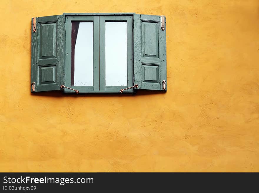 Green wooden windows on orange wall. Green wooden windows on orange wall