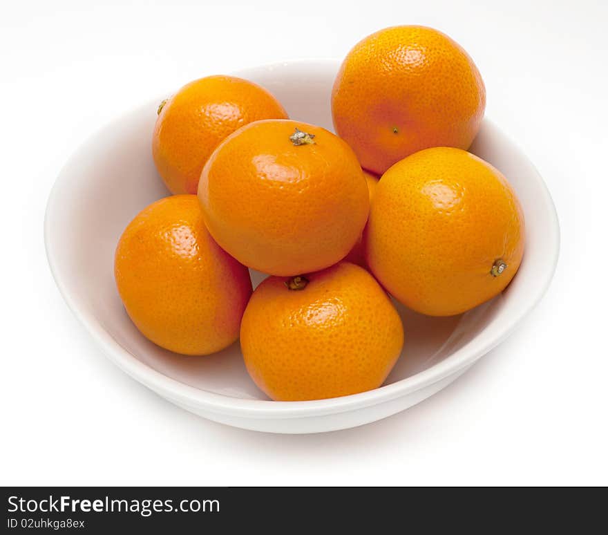 White ceramic bowl with orange mandarines. White ceramic bowl with orange mandarines.