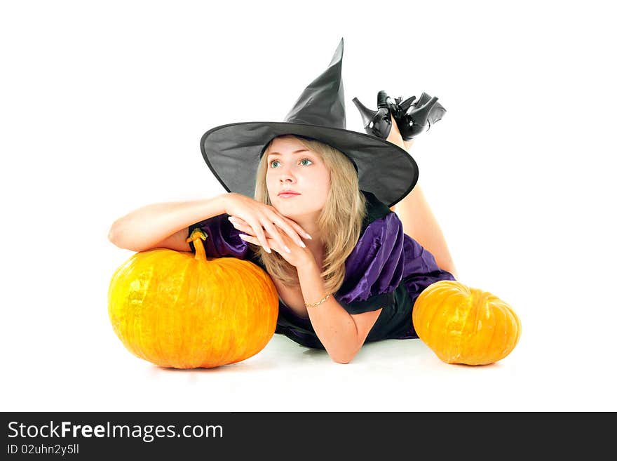 Young blond girl witch sitting beside pumpkins