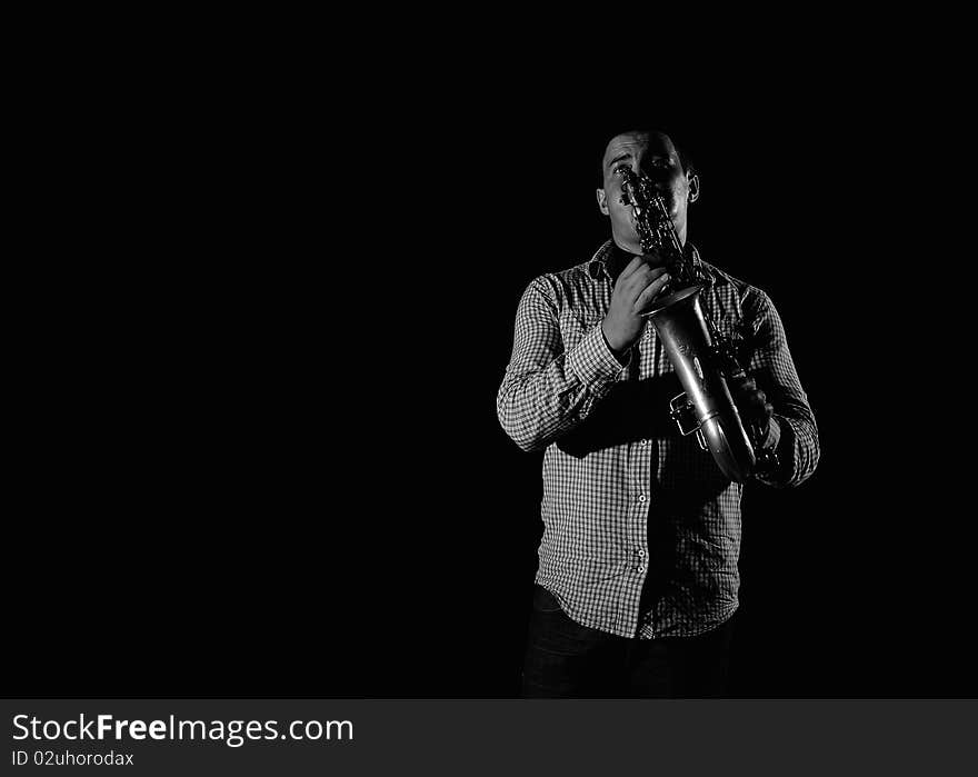 Young handsome man playing music on saxophone