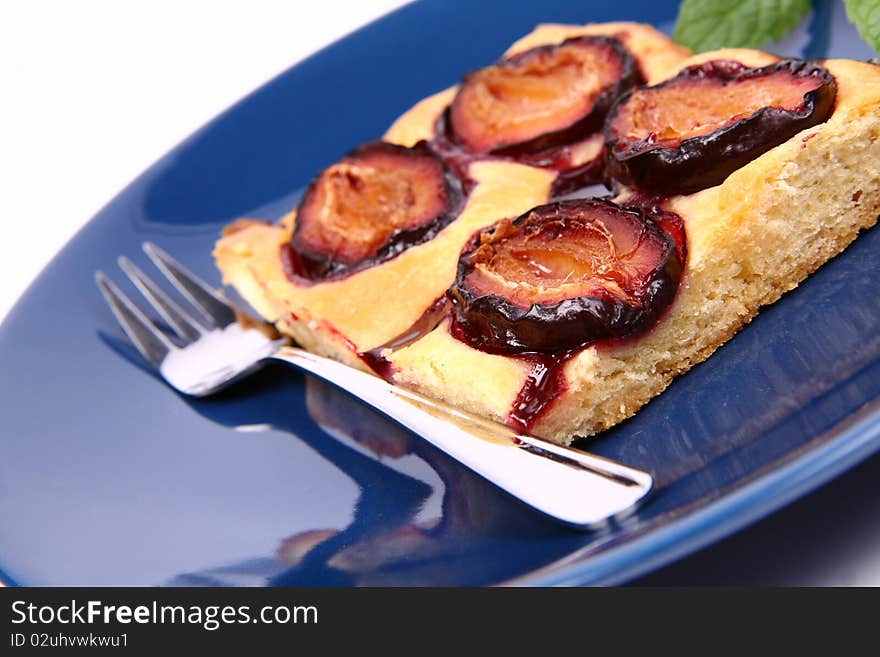 Piece of Plum Pie on a blue plate decorated with a mint twig