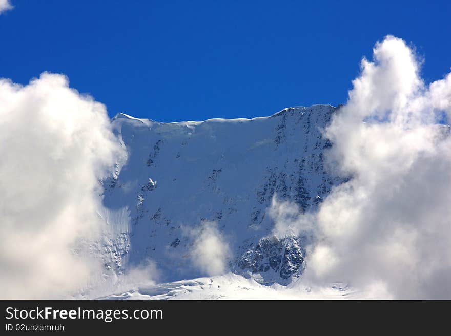 Mountain top flanked by clouds