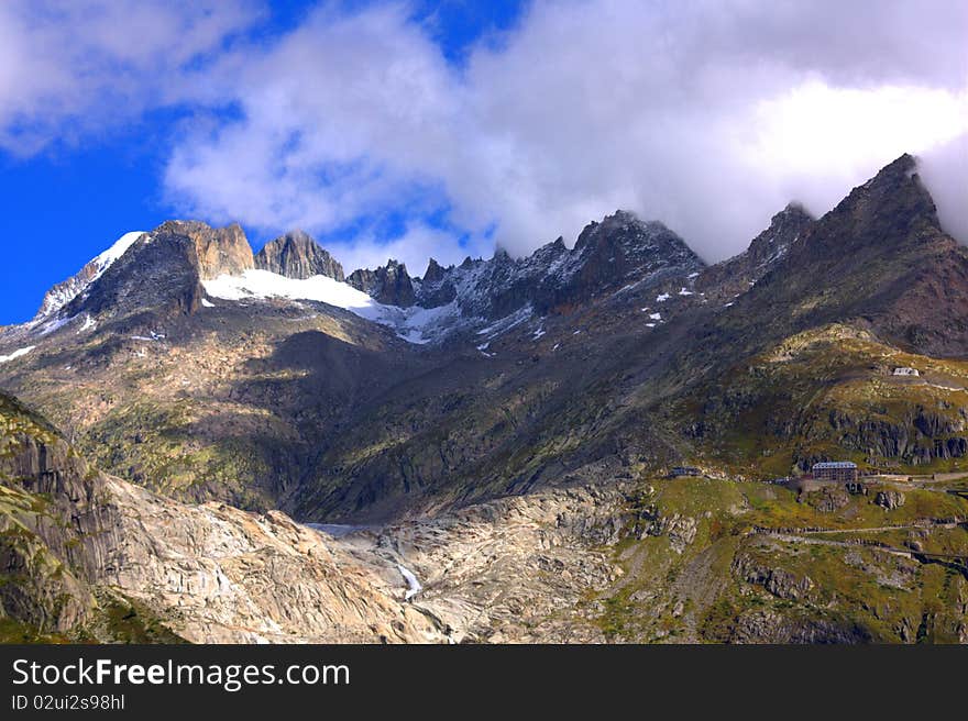 Clouds above a snowy mountain above a glacier