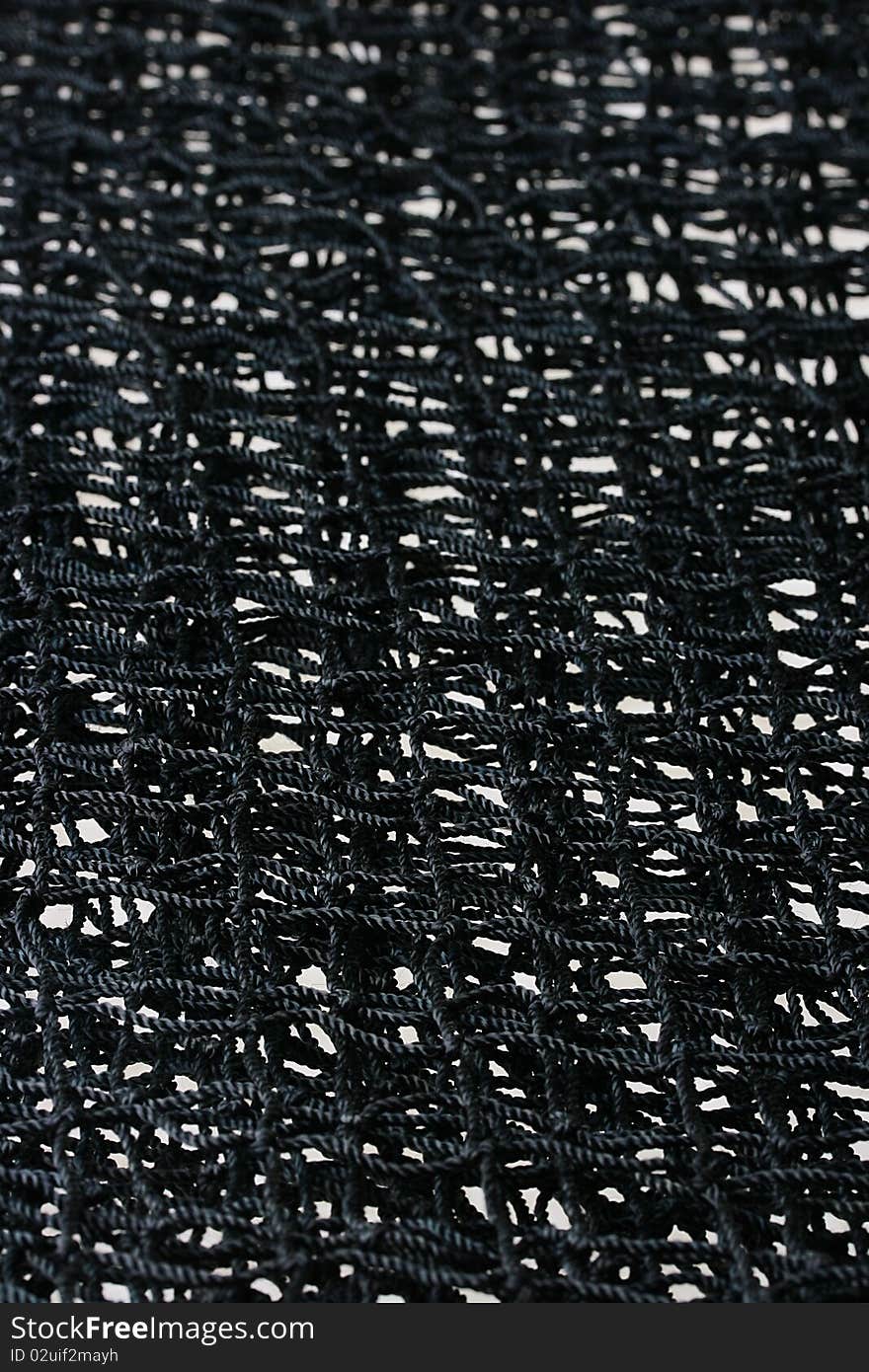 A black badminton net laying on a white isolated background.