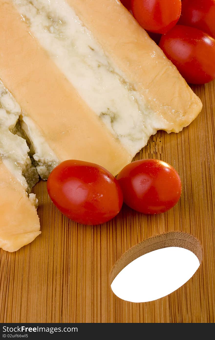 Gloucester cheese with Cheese blue slice on a wood desk with tomato. Gloucester cheese with Cheese blue slice on a wood desk with tomato.