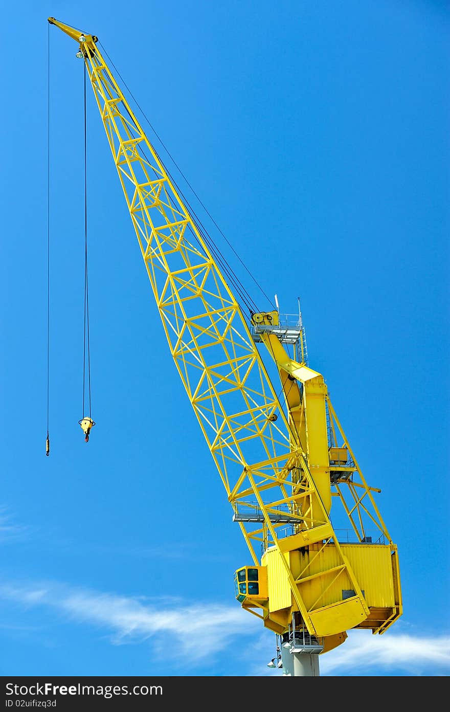 Yellow crane against blues sky with cloud