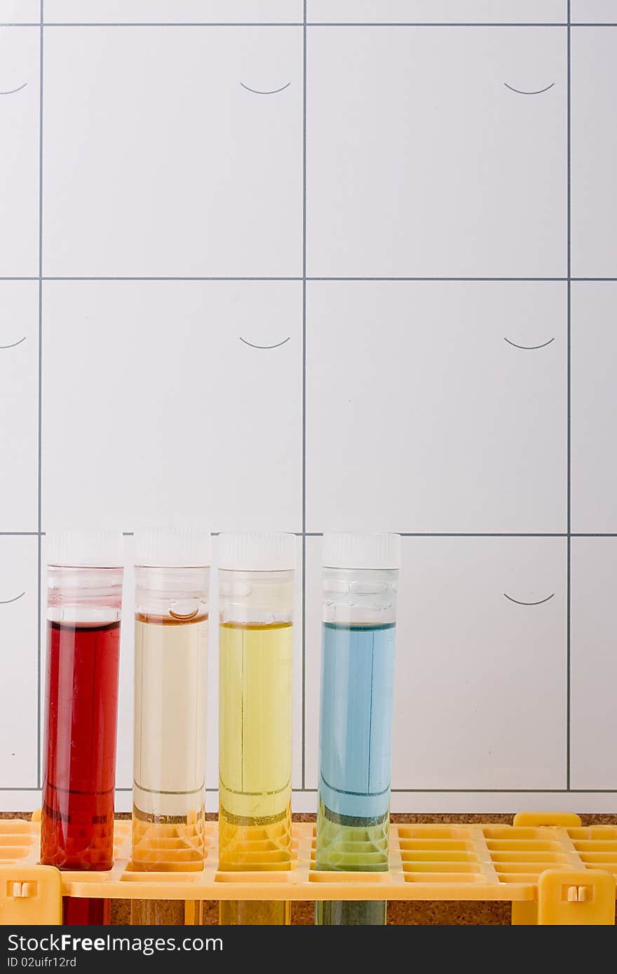 Test tubes in a test tube rack in front of a calendar.