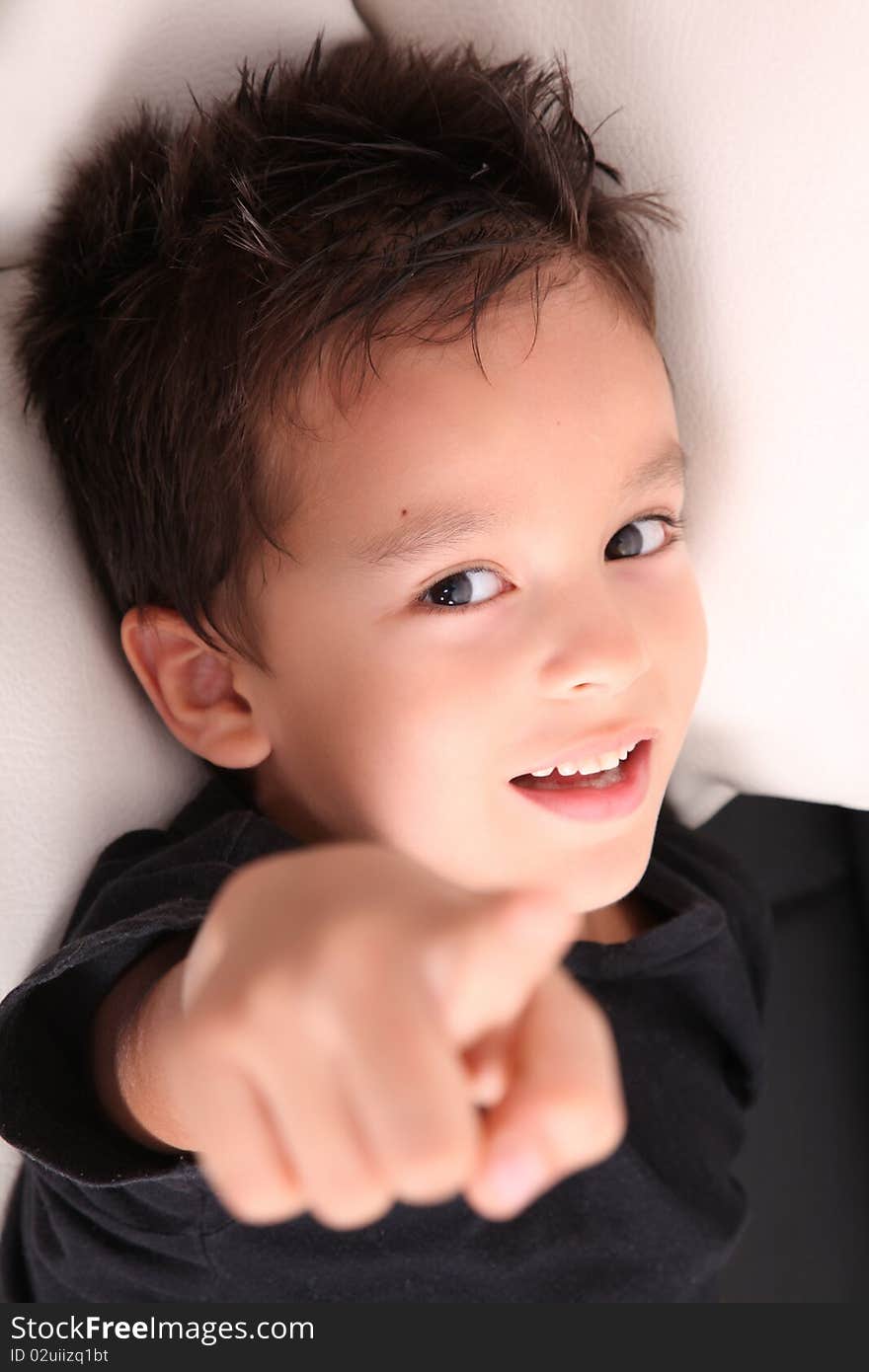 Happy school boy pointing at the camera over white background. Happy school boy pointing at the camera over white background