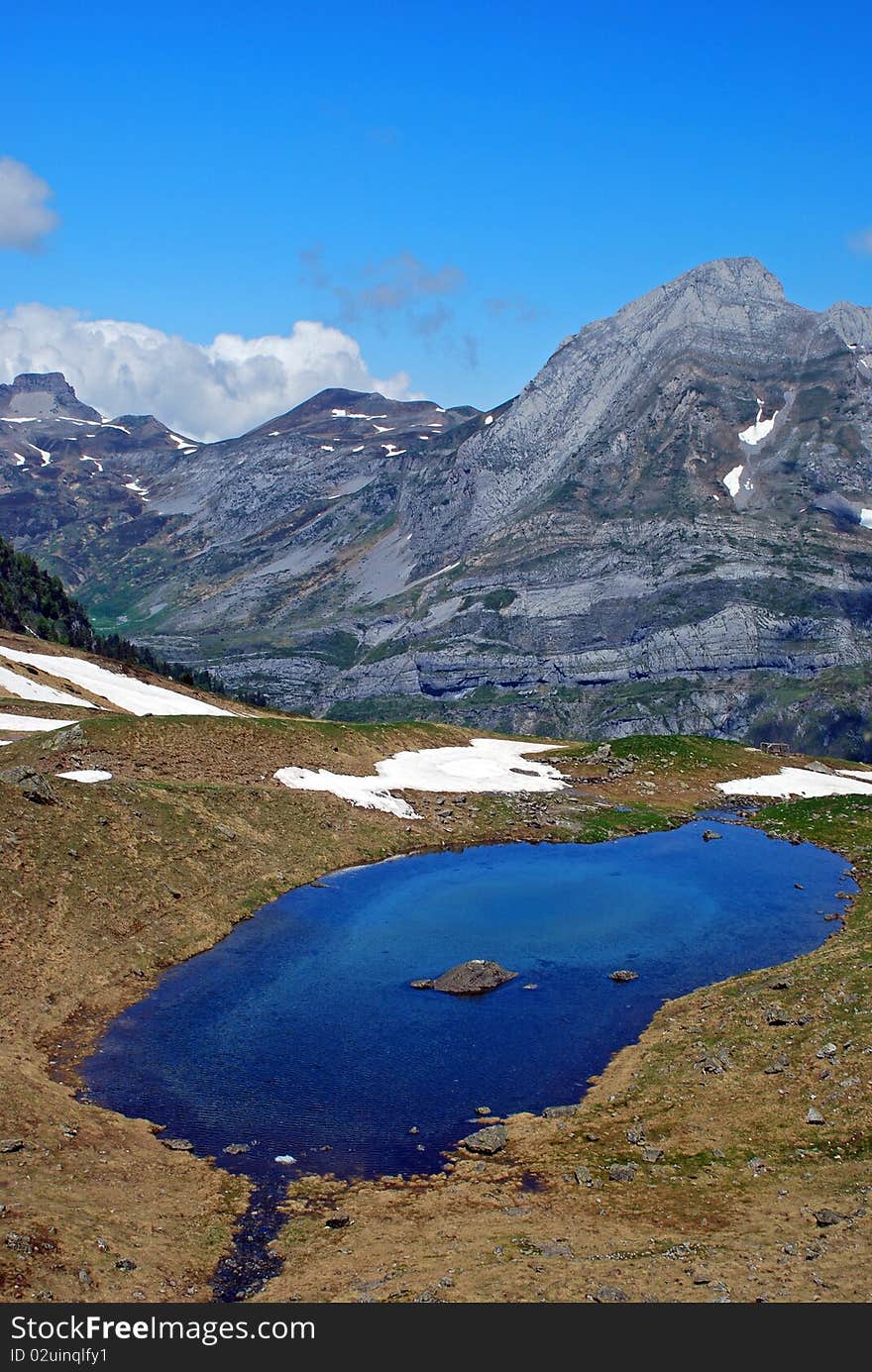 The little Train of Artouste, the highest railway in Europe, at 2000 m of altitude it brings us to Artouste Lake, the view at Seous pond with small refuge behind. The little Train of Artouste, the highest railway in Europe, at 2000 m of altitude it brings us to Artouste Lake, the view at Seous pond with small refuge behind