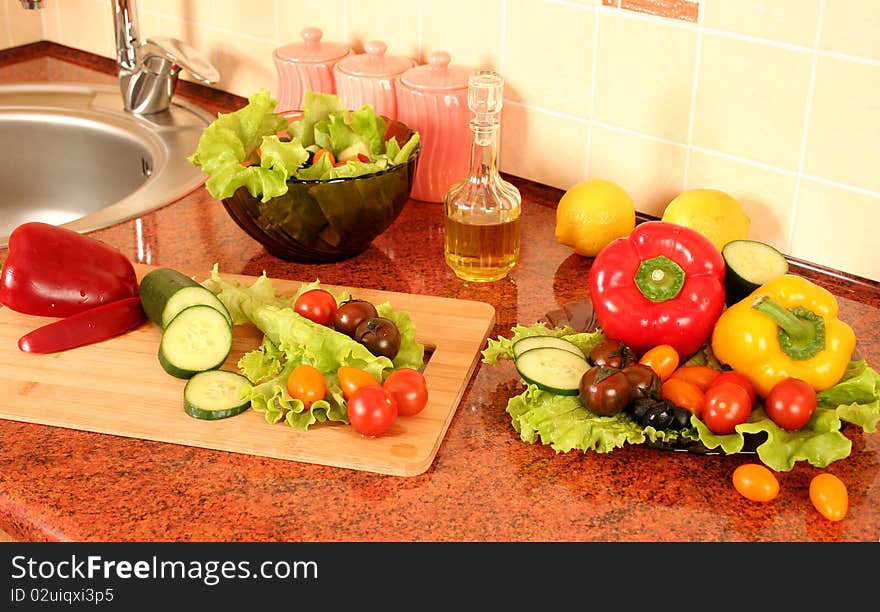 Fresh vegetables and olive oil on a kitchen table. Fresh vegetables and olive oil on a kitchen table