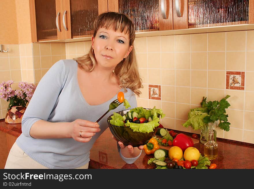 Adult woman preparing salad at domestic kitchen