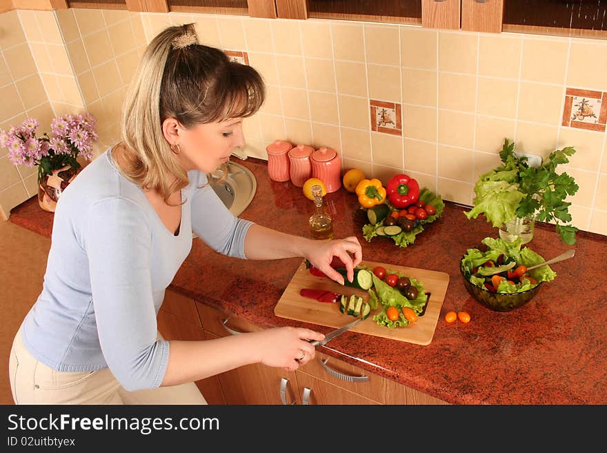 Adult woman preparing salad at domestic kitchen