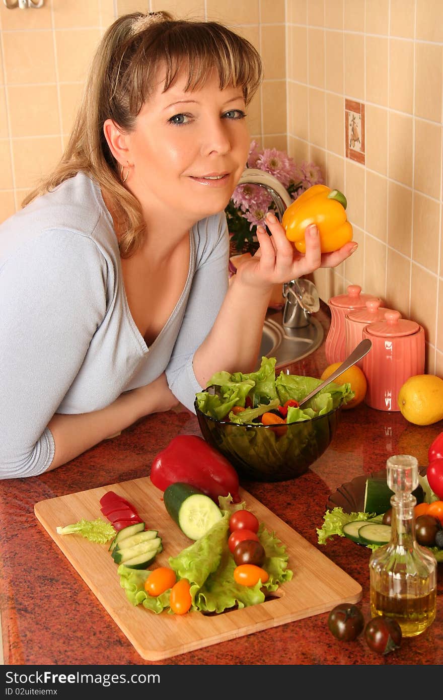 Adult woman preparing salad at domestic kitchen. Adult woman preparing salad at domestic kitchen