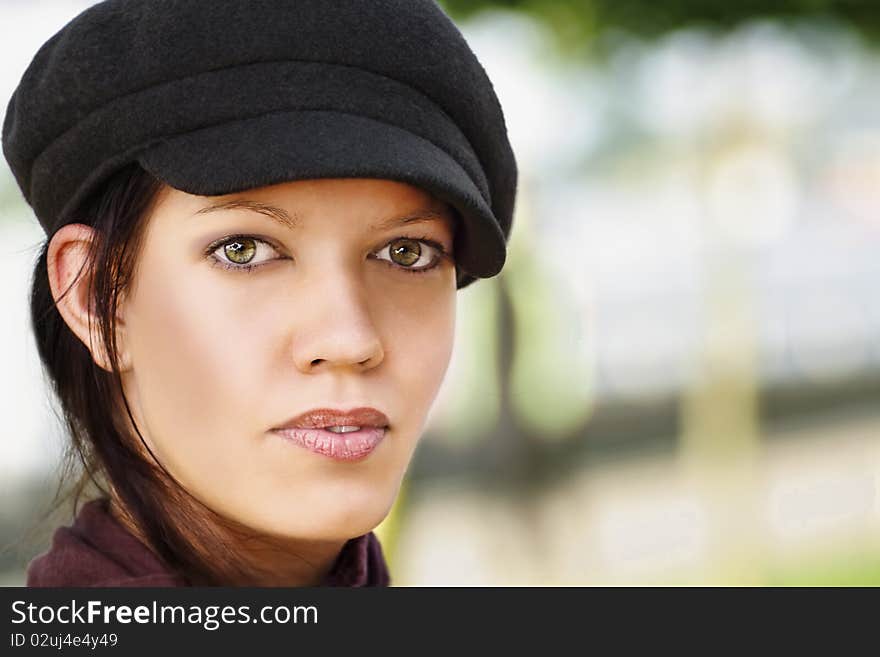 Stylish young woman with cap, outdoors