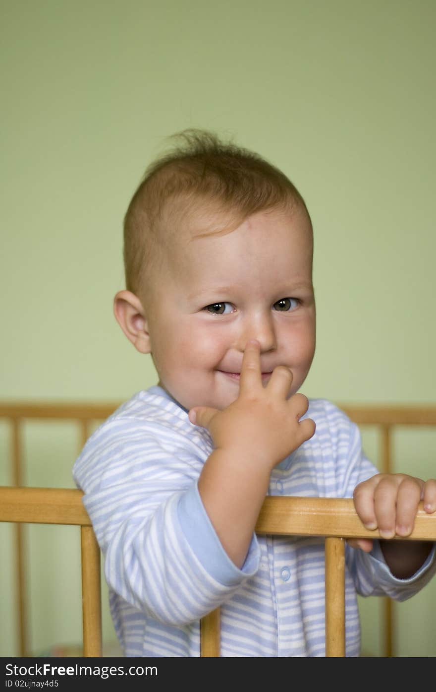 Baby child in bed on green