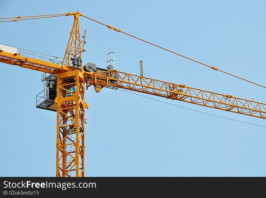 Closeup of yellow jib crane against blue sky. Closeup of yellow jib crane against blue sky