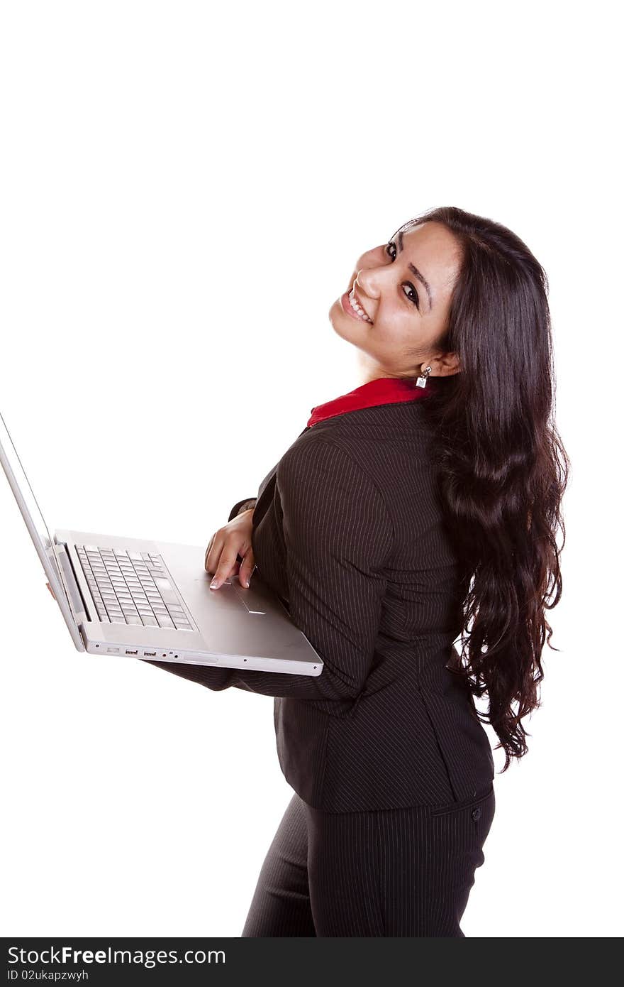 A woman is standing holding a laptop and smiling. A woman is standing holding a laptop and smiling.