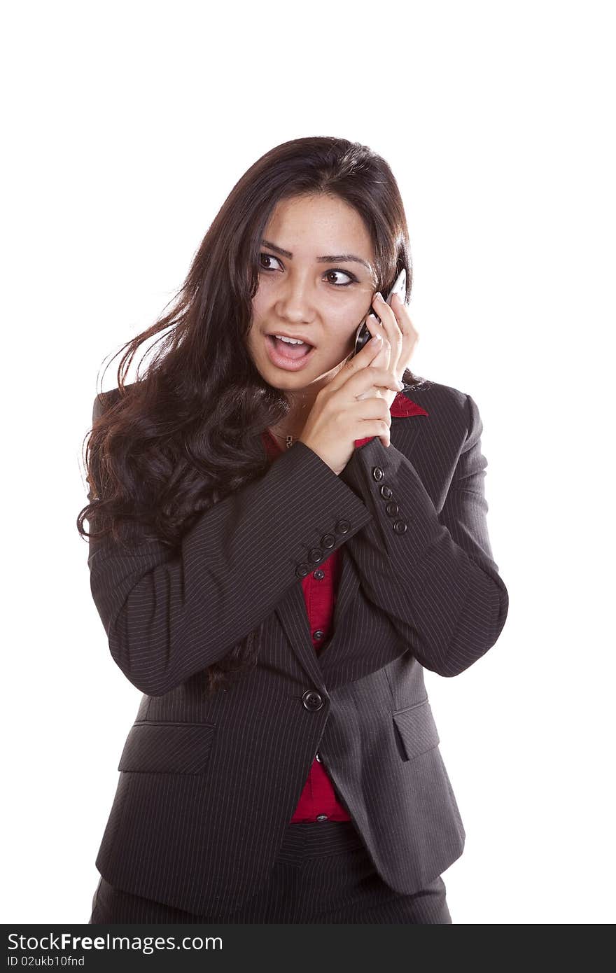 A woman is talking on her phone with a surprised expression on her face. A woman is talking on her phone with a surprised expression on her face.