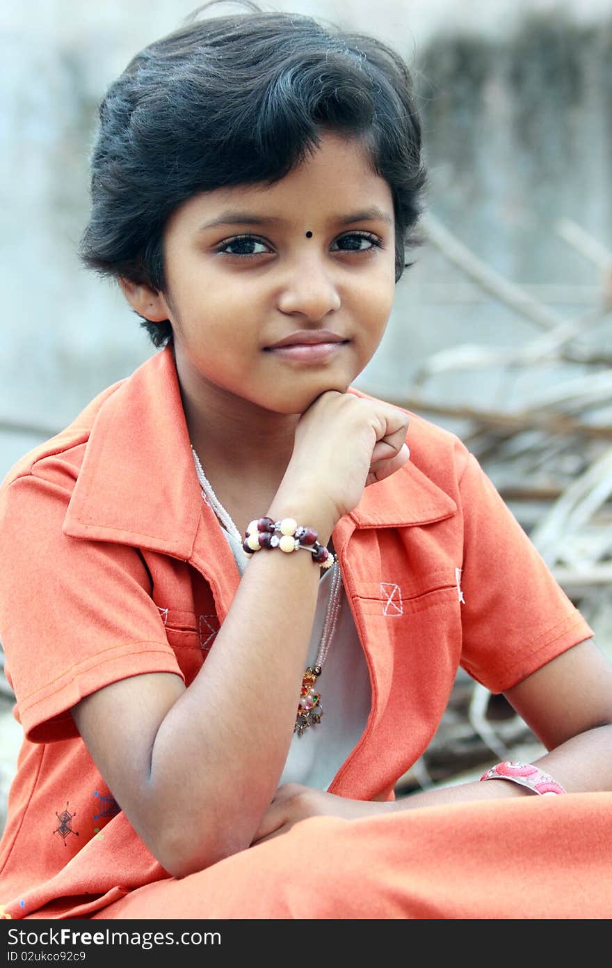 Portrait of Indian Teenage Girl Sitting on a Stone