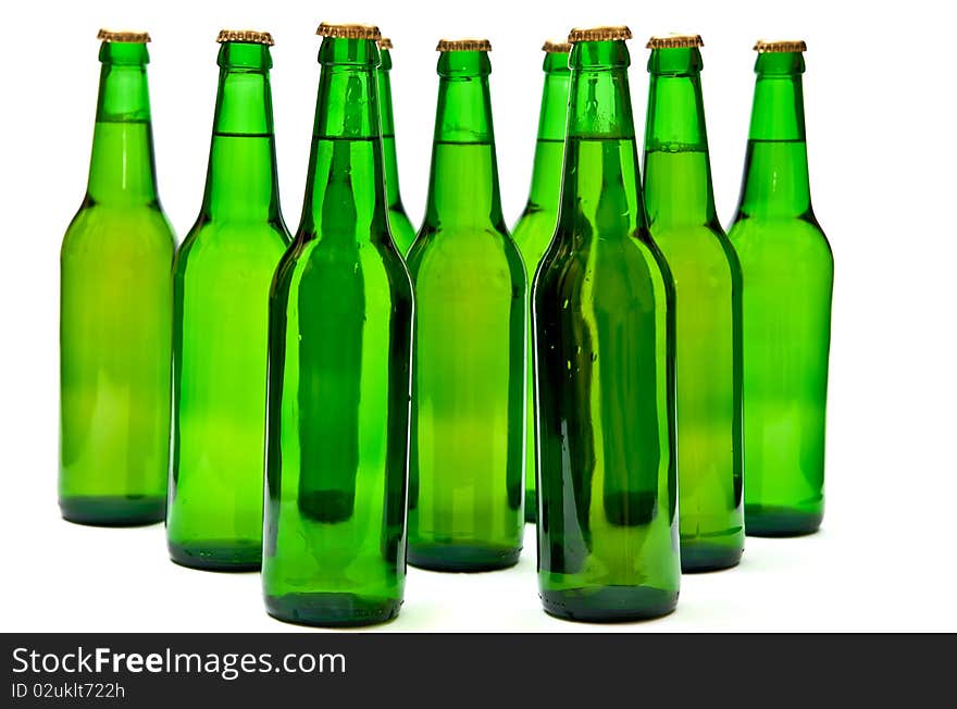 Rows from beer bottles on white background.