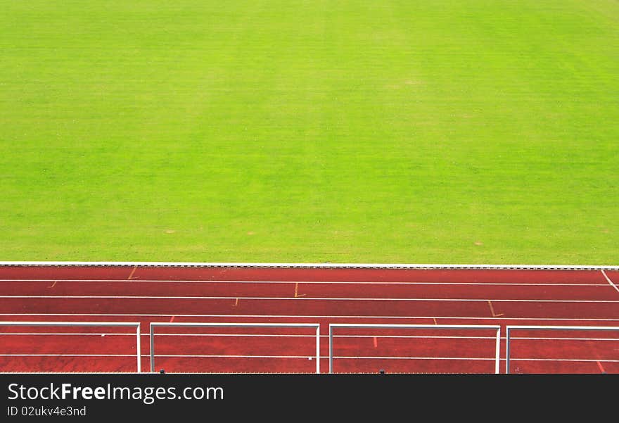 Red athletics track with green field