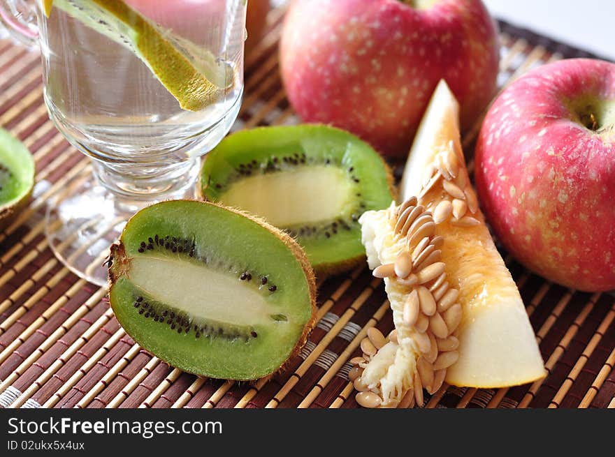 Kiwi, apples, lobule of melon, lie on a table. Kiwi, apples, lobule of melon, lie on a table