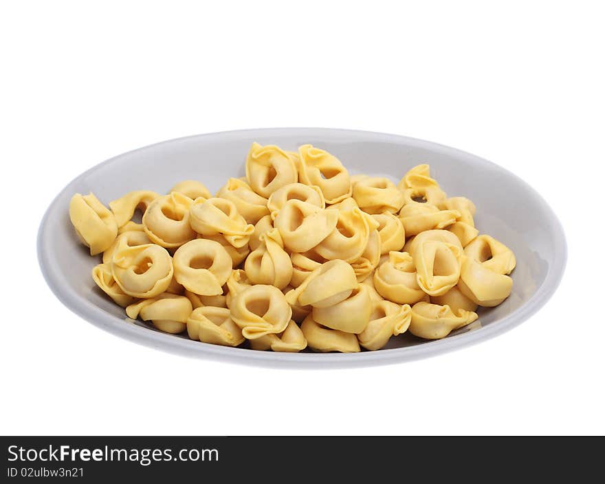 Uncooked tortelini on plate isolated over white background. Uncooked tortelini on plate isolated over white background