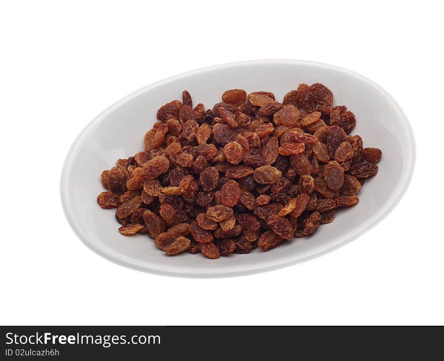 Brown raisins on plate isolated over white background. Brown raisins on plate isolated over white background