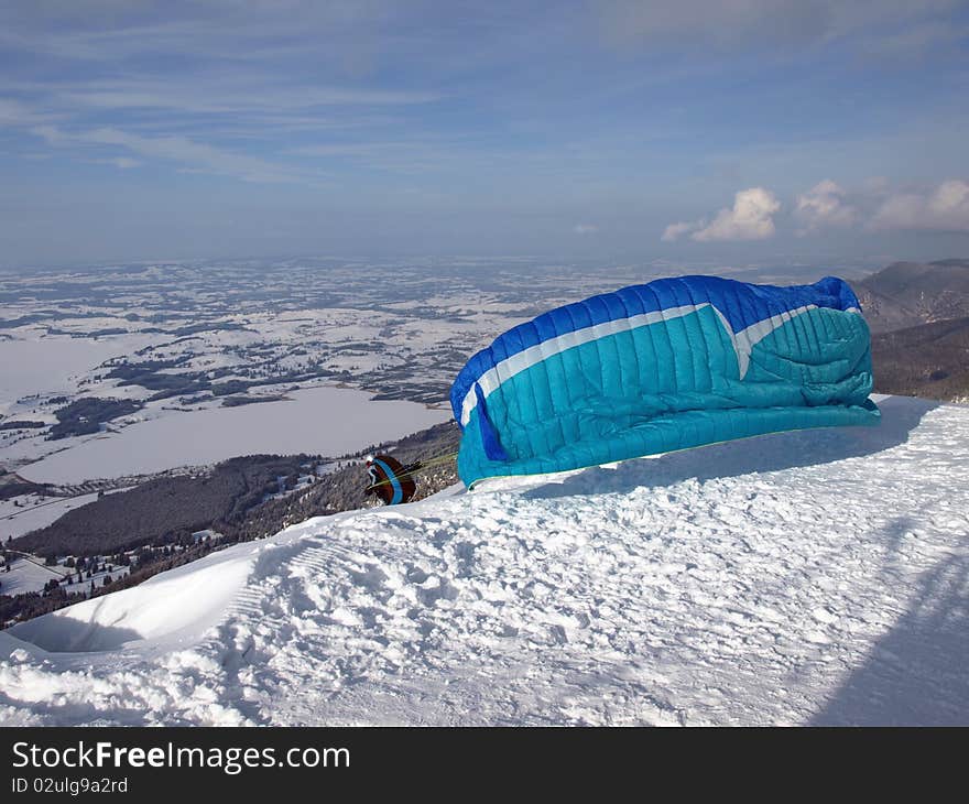 Paraglider running down a slope on a mountain