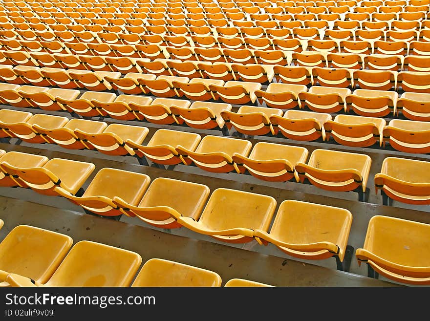 Perspective of yellow seats in football stadium, pattern background