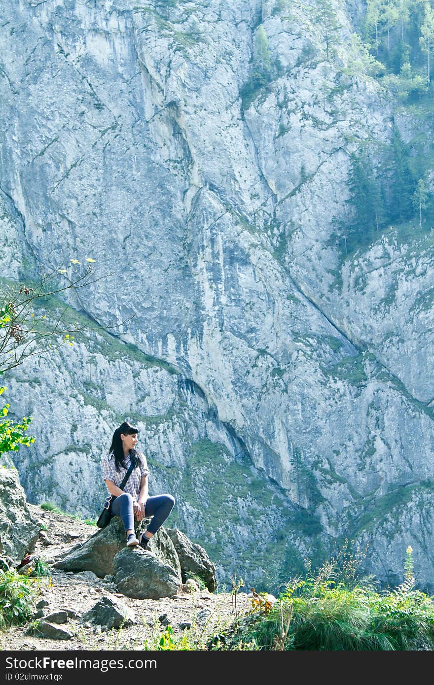 Woman sitting at the edge of a cliff. Woman sitting at the edge of a cliff